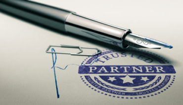 Trusted partner mark imprinted on a paper texture with signature and fountain pen. Concept image for illustration of trust in partnership and business services.